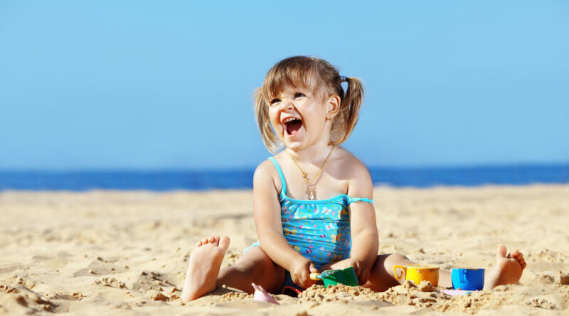 little girl is playing on the beach