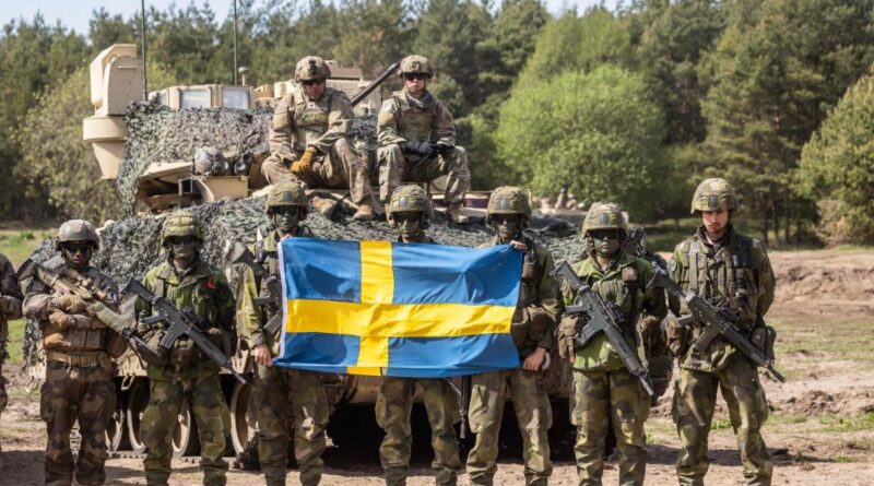 soldiers in front of a tank with the Swedish flag