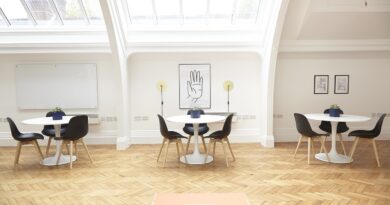 three white tables with three black chairs each