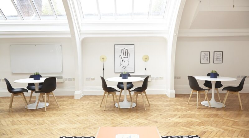 three white tables with three black chairs each