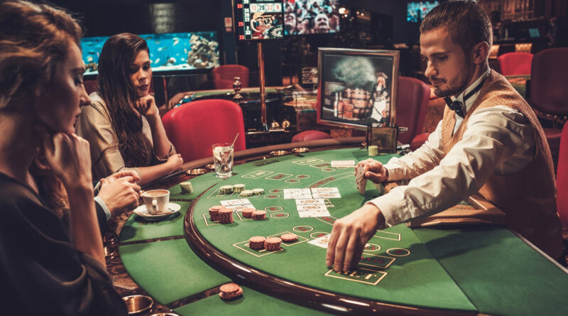 women playing poker in a casino with a croupier