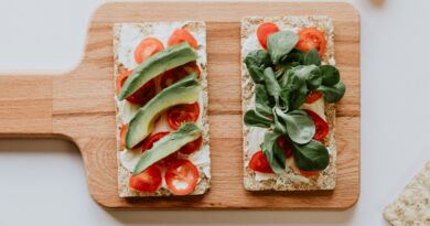 sandwich with avocado, tomatoes and spinach on a board