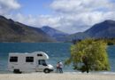 Couple outside camper looking at lake