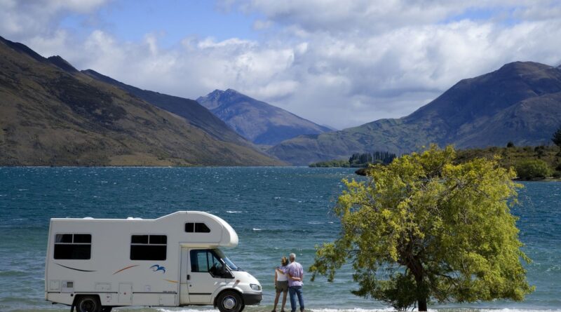 Couple outside camper looking at lake